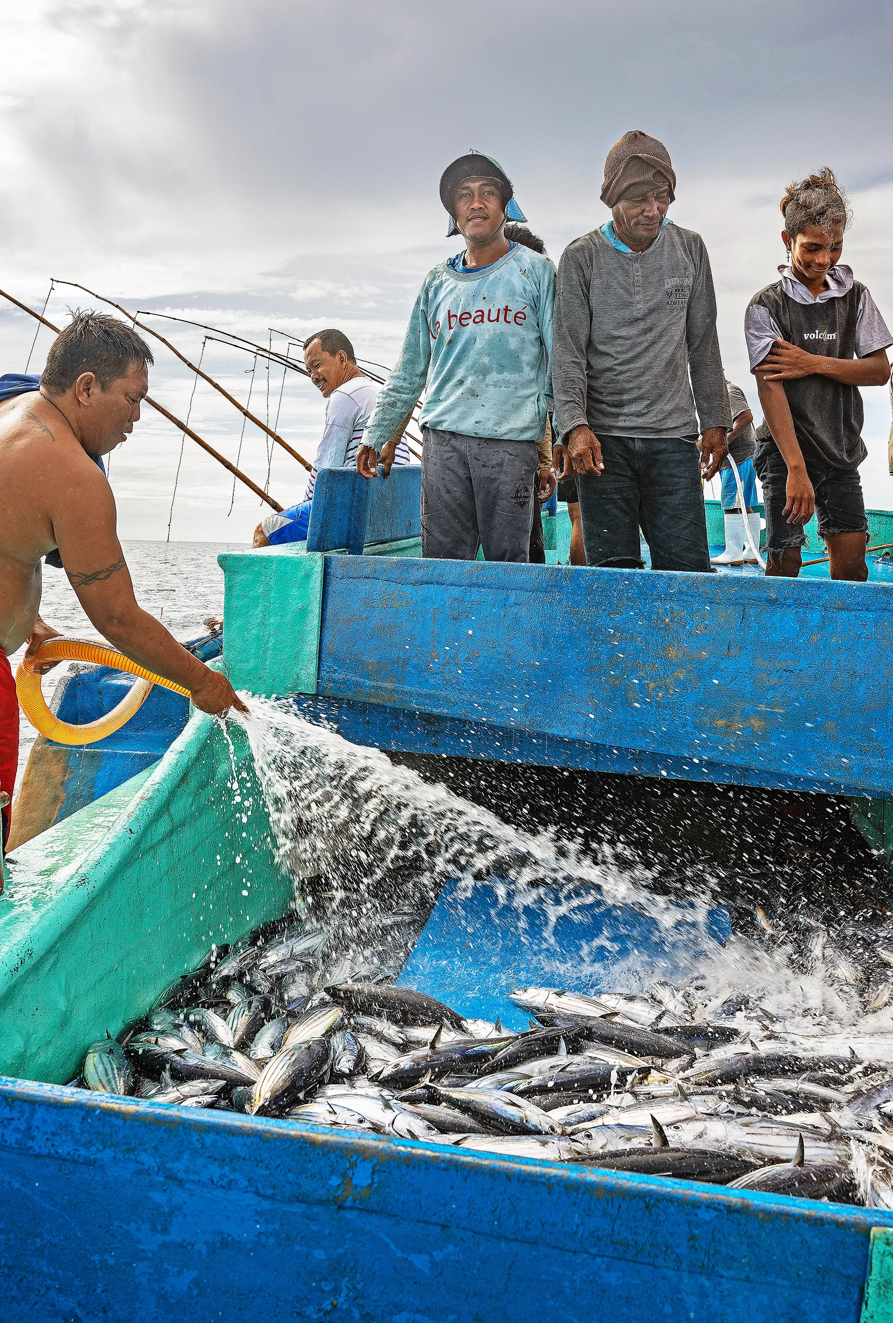 Vissers in Bitung maken de vangst schoon aan boord in Bitung. 