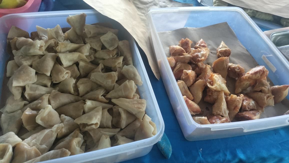 Golden fried dumplings, one cut open revealing a savory, reddish-orange filling.