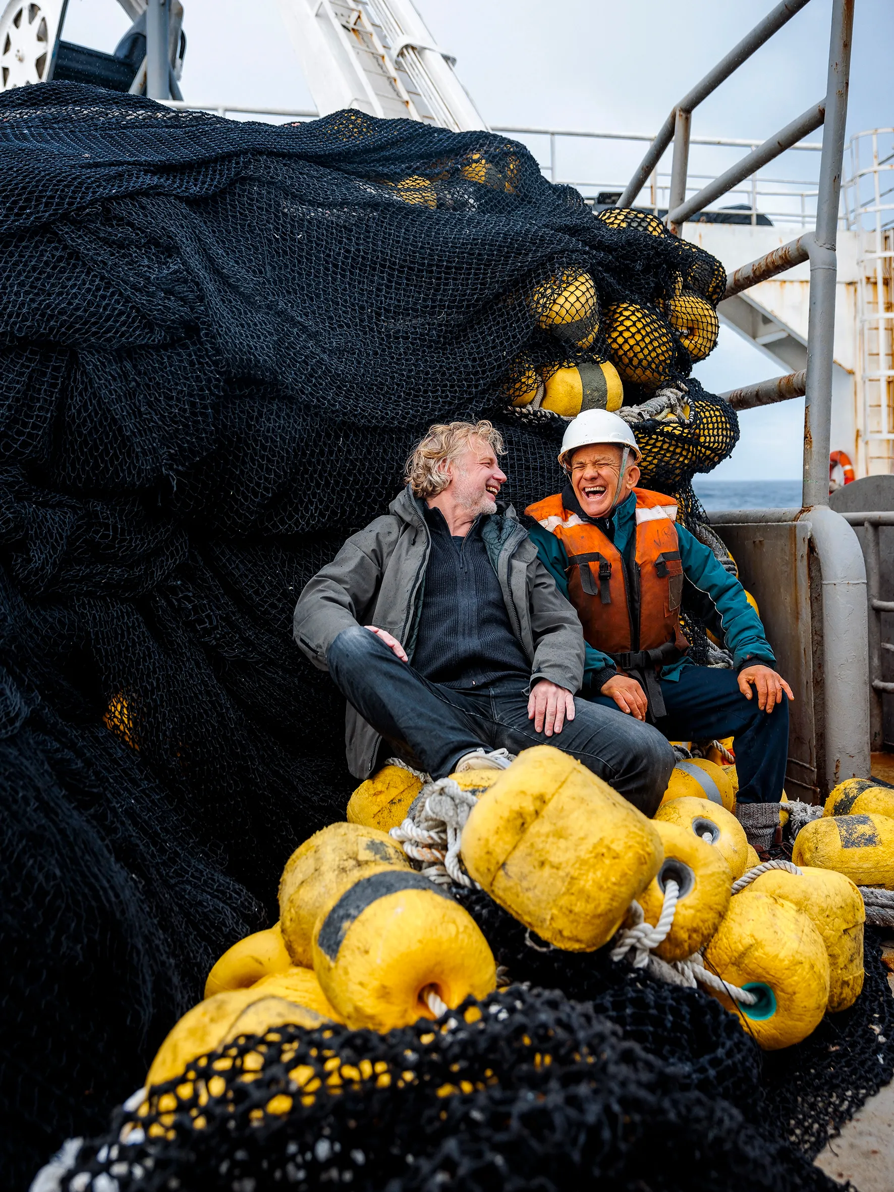 Visser in Chili en Bart zitten samen op de boot en lachen naar elkaar. 